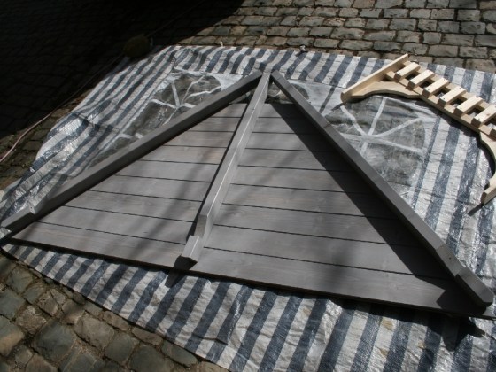 Die Grundfarbe ist Palatium-Grau, dazu kommen blaue und rote Farbanteile. Die FArbe soll den Garten und die Blumen nicht dominieren.