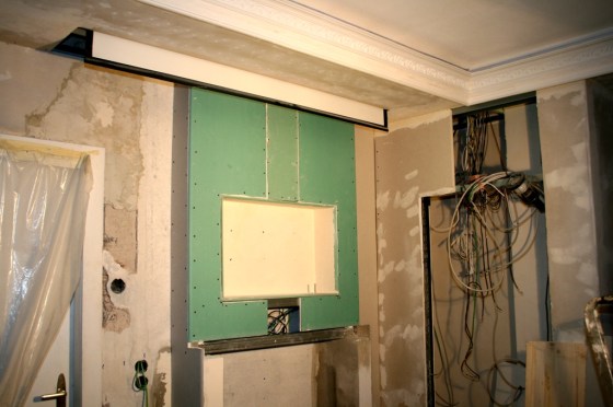 Der Kamin wird mit Rigips verkleidet. Der obere Teil wird von einer Promasil-Platte gegen die Hitze des Ofens geschützt. Die Knauf-Profile wurden ausgeschäumt, um Vibrationsgeräusche zu vermeiden.